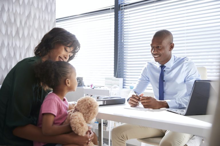 Mother And Daughter In Consultation With Doctor In Office
