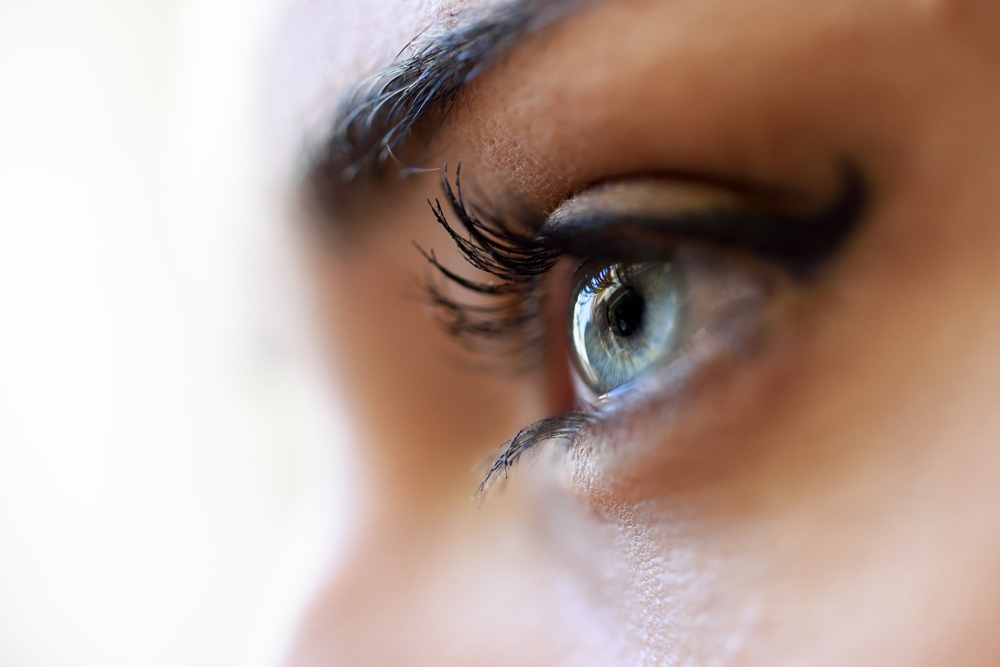 Close-up of young woman's blue eyes with long eyelashes
